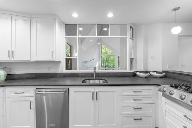 kitchen with stainless steel appliances, white cabinetry, dark countertops, and recessed lighting