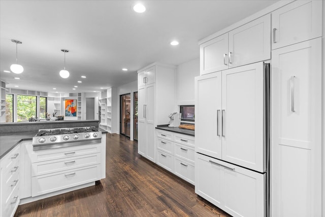 kitchen featuring paneled refrigerator, dark countertops, stainless steel gas stovetop, white cabinetry, and recessed lighting