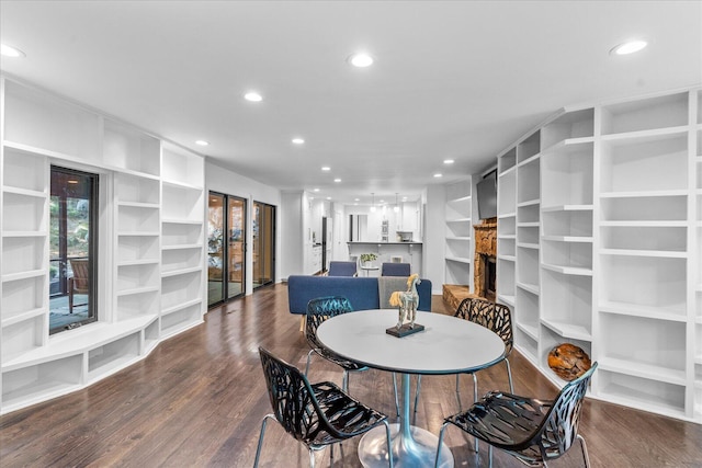 dining space with recessed lighting, wood finished floors, and a stone fireplace