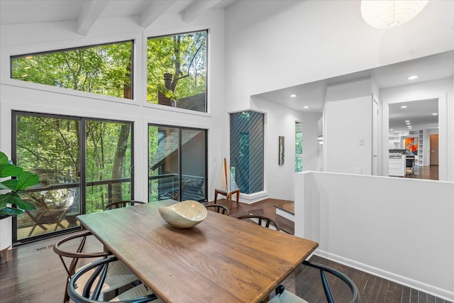 dining area with a high ceiling, plenty of natural light, wood finished floors, beamed ceiling, and recessed lighting