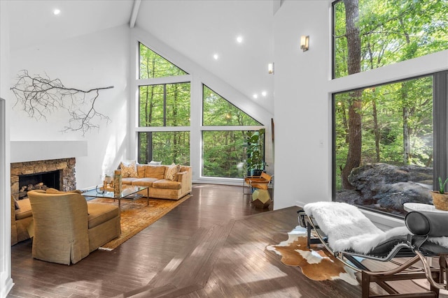 living room with high vaulted ceiling, a fireplace, and beamed ceiling