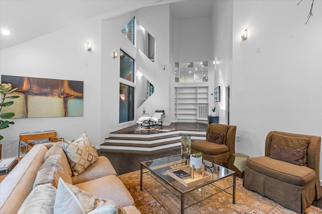 living room with a high ceiling, wood finished floors, and recessed lighting
