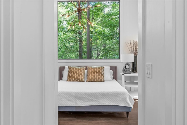 bedroom featuring wood finished floors and a chandelier