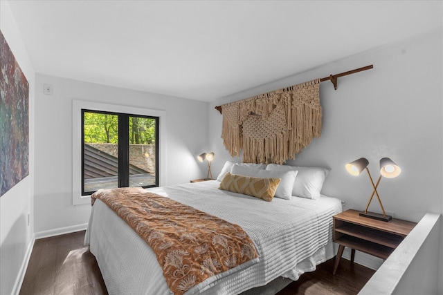 bedroom featuring wood finished floors, baseboards, and access to outside