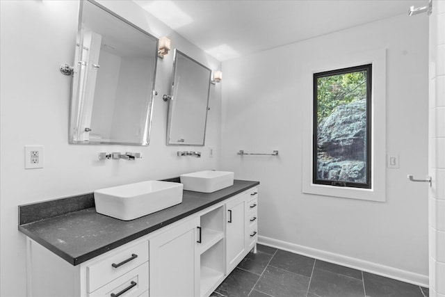 bathroom with baseboards and double vanity