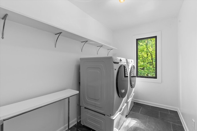 clothes washing area featuring washing machine and clothes dryer and baseboards