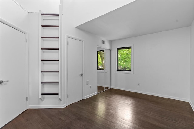 unfurnished bedroom with wood finished floors and baseboards