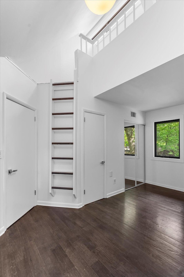 unfurnished living room featuring wood finished floors and baseboards