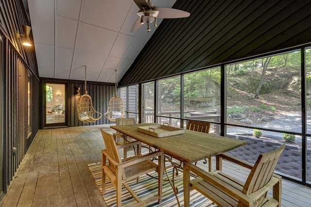 sunroom featuring a ceiling fan, vaulted ceiling, and outdoor dining area