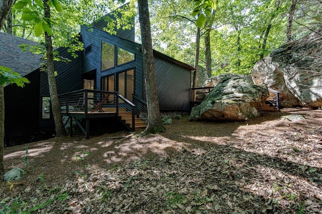 back of property with a wooden deck and stairway