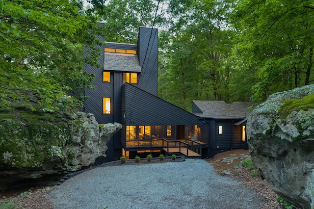 rear view of property featuring a porch and a chimney