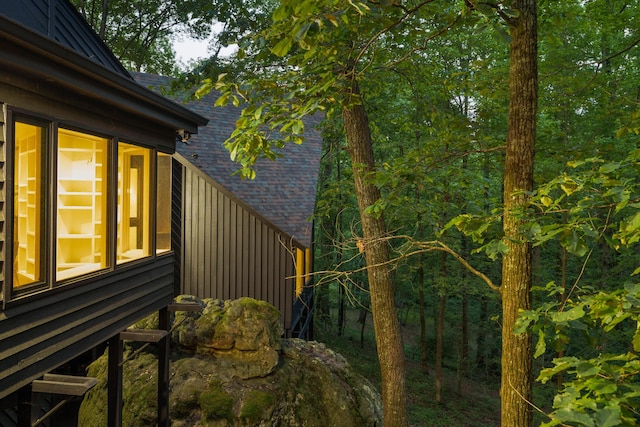 view of property exterior featuring roof with shingles and board and batten siding