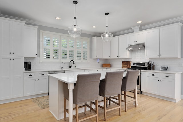 1328 Carrington Way, Chattanooga, TN 37405 - kitchen with gas range, under cabinet range hood, light countertops, ornamental molding, and light wood-style floors