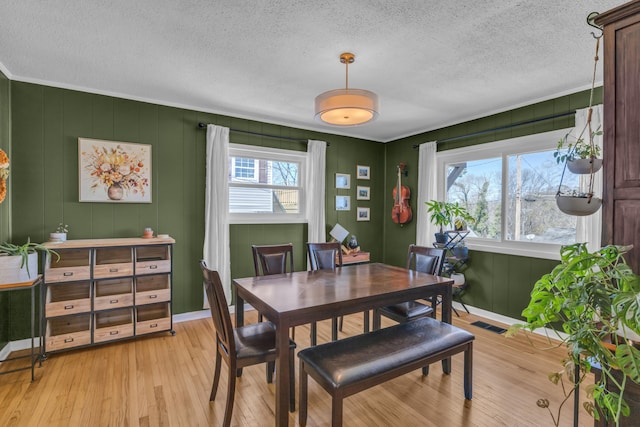 3804 Northview Ave, Chattanooga, TN 37412 - dining area featuring light wood-style flooring, a textured ceiling, baseboards, ornamental molding, and a decorative wall