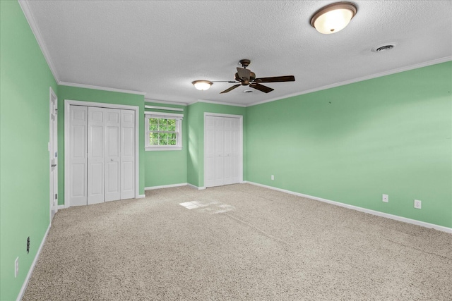 1578 Old Ringgold Rd, Rocky Face, GA 30740 - unfurnished bedroom featuring two closets, a textured ceiling, crown molding, baseboards, and carpet flooring