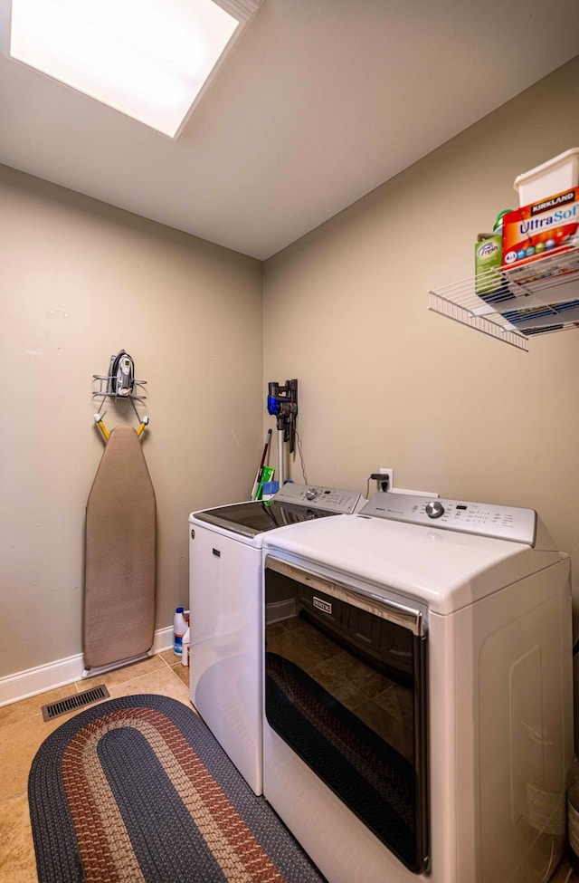 clothes washing area featuring washing machine and dryer and baseboards