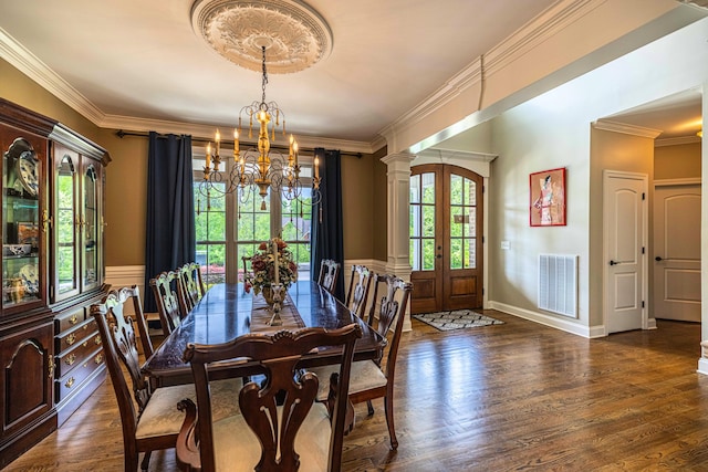 dining space with french doors, a chandelier, wood finished floors, crown molding, and decorative columns