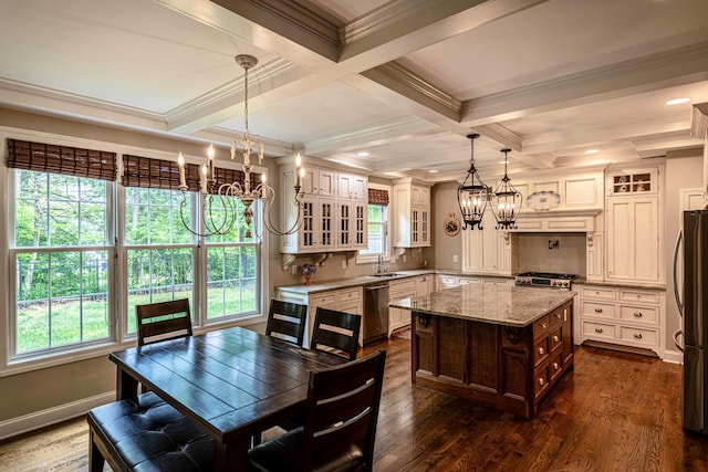kitchen featuring a chandelier, a sink, stainless steel appliances, glass insert cabinets, and plenty of natural light