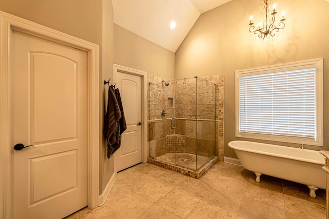 bathroom with a stall shower, lofted ceiling, a freestanding tub, and a chandelier