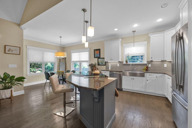 7310 Huntley Ln, Chattanooga, TN 37421 - kitchen with appliances with stainless steel finishes, crown molding, dark wood finished floors, decorative backsplash, and dark stone counters