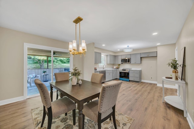 dining room featuring light wood-style floors, healthy amount of natural light, baseboards, and recessed lighting