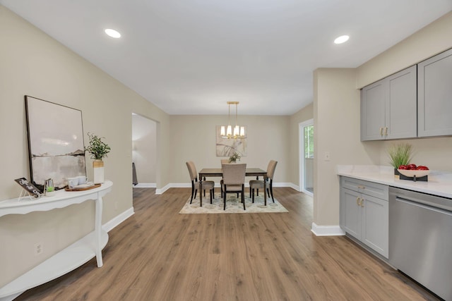 dining room featuring light wood-style floors, a chandelier, baseboards, and recessed lighting