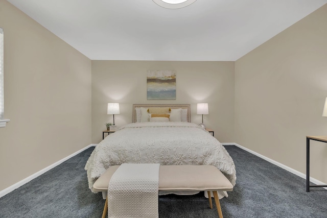 bedroom with dark carpet and baseboards