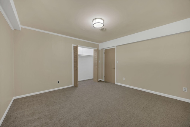 unfurnished bedroom featuring carpet, baseboards, and ornamental molding
