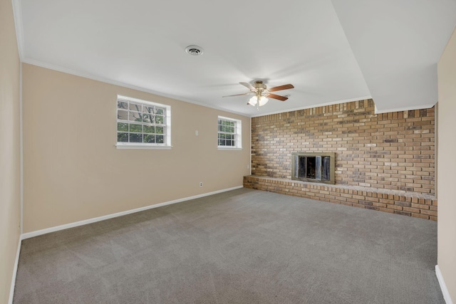 unfurnished living room featuring a ceiling fan, ornamental molding, carpet flooring, baseboards, and a fireplace