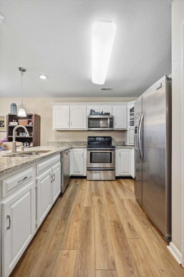 548 Flagstone Dr, Rossville, GA 30741 - kitchen featuring appliances with stainless steel finishes, a sink, white cabinets, light wood finished floors, and recessed lighting