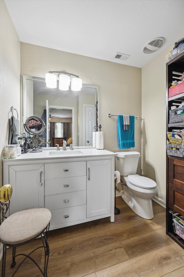 548 Flagstone Dr, Rossville, GA 30741 - bathroom with wood finished floors, vanity, toilet, and a textured wall