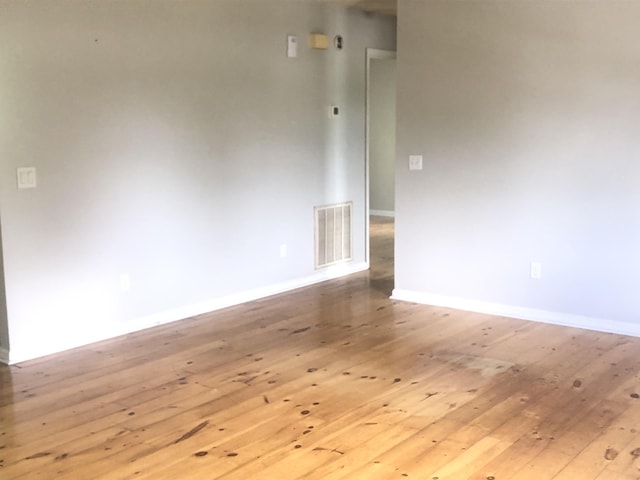 unfurnished room with hardwood / wood-style floors and baseboards