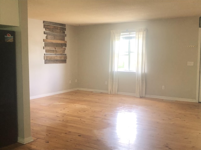 empty room with light wood-style floors and baseboards