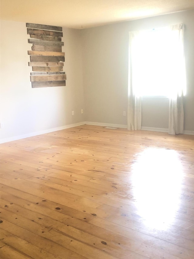 empty room with light wood-style floors and baseboards