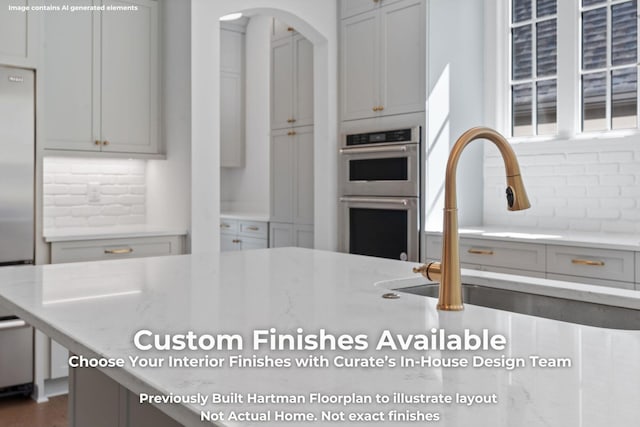 3070 Galena Cir Unit 830, Chattanooga, TN 37419 - kitchen featuring appliances with stainless steel finishes, backsplash, arched walkways, and light stone counters
