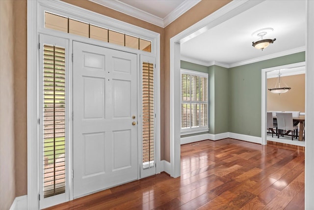 entrance foyer with wood finished floors, ornamental molding, and baseboards