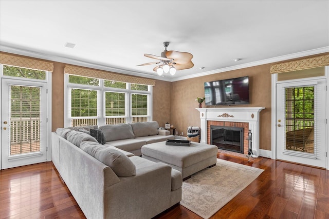 living area featuring hardwood / wood-style flooring, healthy amount of natural light, and crown molding