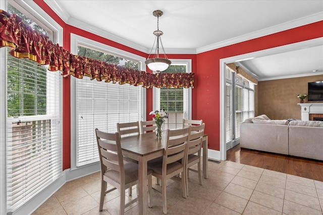 tiled dining room featuring crown molding and baseboards