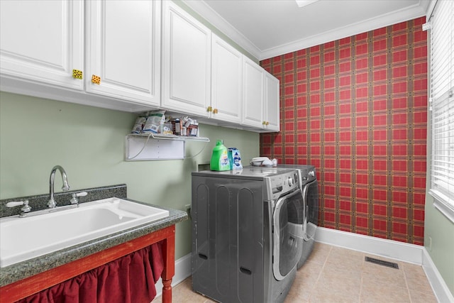 washroom featuring baseboards, washing machine and clothes dryer, cabinet space, wallpapered walls, and light tile patterned floors