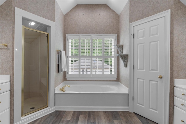 bathroom with vanity, vaulted ceiling, wood finished floors, a stall shower, and wallpapered walls