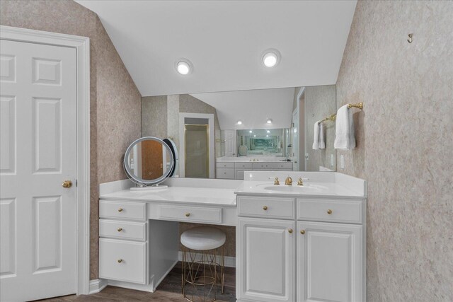 full bathroom featuring wallpapered walls, vaulted ceiling, vanity, and wood finished floors