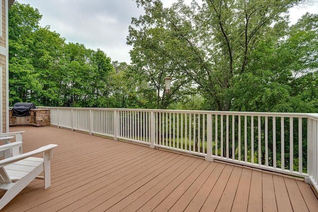 wooden deck with view of wooded area
