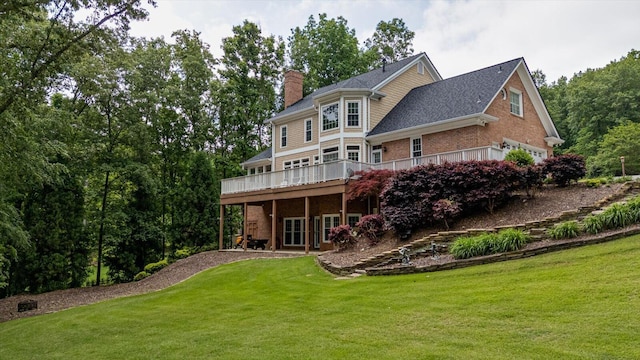 rear view of house featuring a chimney, a deck, a lawn, and brick siding