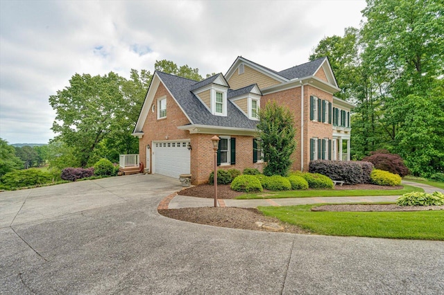 view of front of house with brick siding, concrete driveway, and a shingled roof