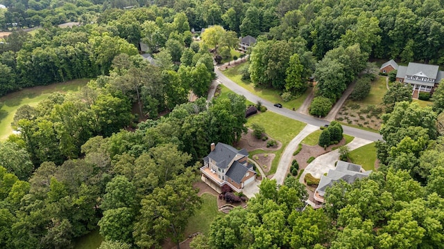 aerial view of property and surrounding area featuring a heavily wooded area