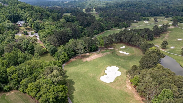 aerial view of property's location featuring a large body of water, a golf club, and a forest