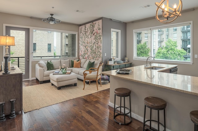 200 Manufacturers Rd Apt 339, Chattanooga, TN 37405 - kitchen with a sink, a chandelier, light stone counters, dark wood-type flooring, and a kitchen bar