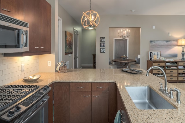 200 Manufacturers Rd Apt 339, Chattanooga, TN 37405 - kitchen featuring stainless steel appliances, a sink, a chandelier, tasteful backsplash, and light stone countertops