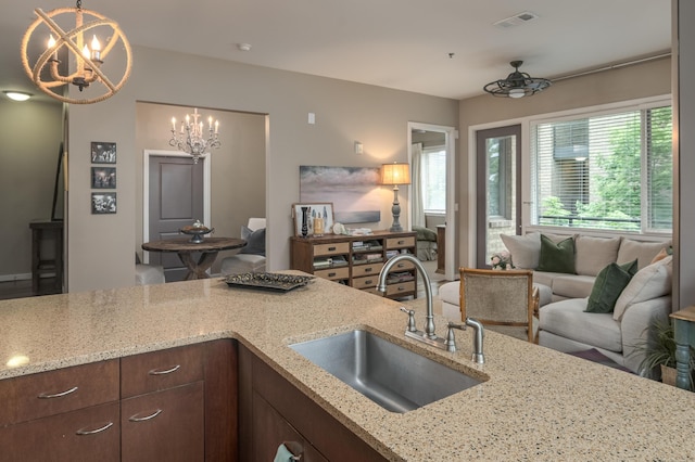 200 Manufacturers Rd Apt 339, Chattanooga, TN 37405 - kitchen featuring a sink, open floor plan, a chandelier, light stone countertops, and decorative light fixtures