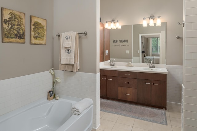 200 Manufacturers Rd Apt 339, Chattanooga, TN 37405 - bathroom featuring a garden tub, double vanity, tile patterned floors, ensuite bathroom, and tile walls